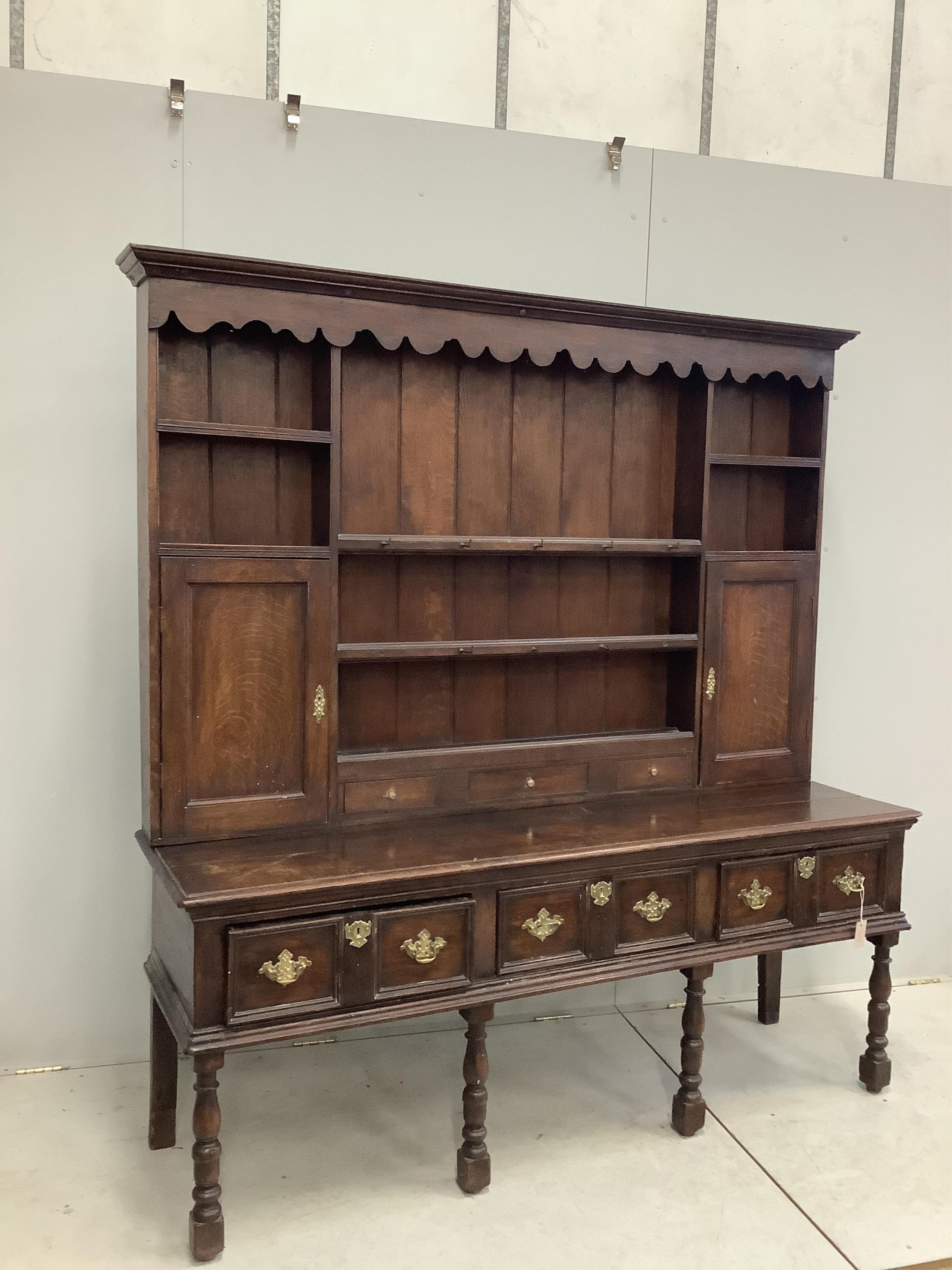 An 18th century style oak dresser with boarded rack, width 178cm, depth 52cm, height 190cm. Condition - fair, surfaces scratched